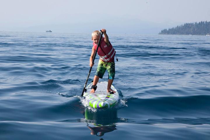 a man riding on the back of a boat in the water